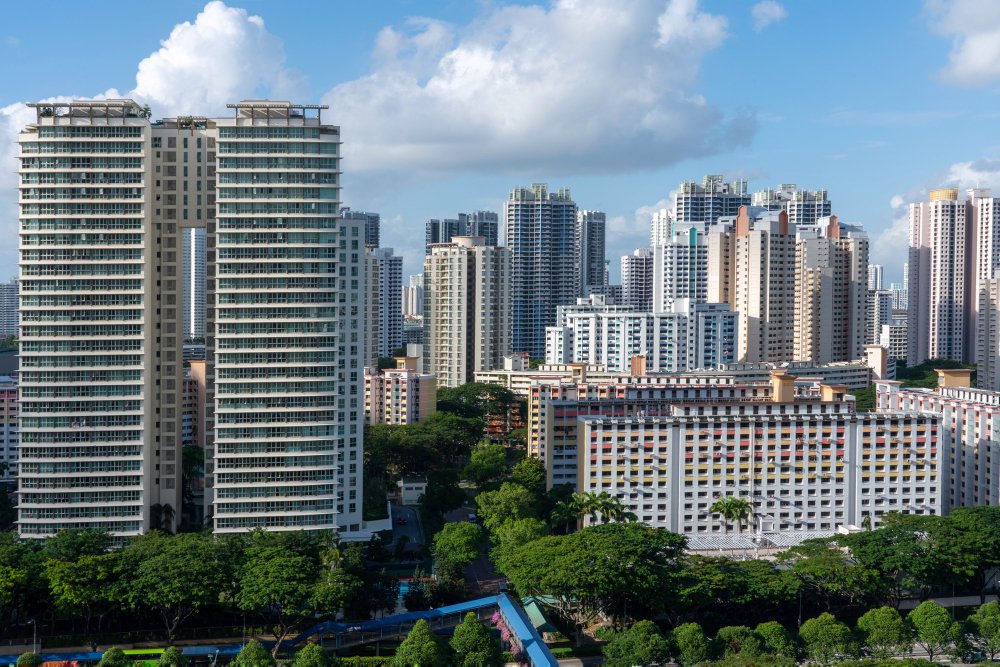 A comparison between commercial and residential properties: A vibrant cityscape blending high-rise buildings, residential and commercial, under a clear blue sky.