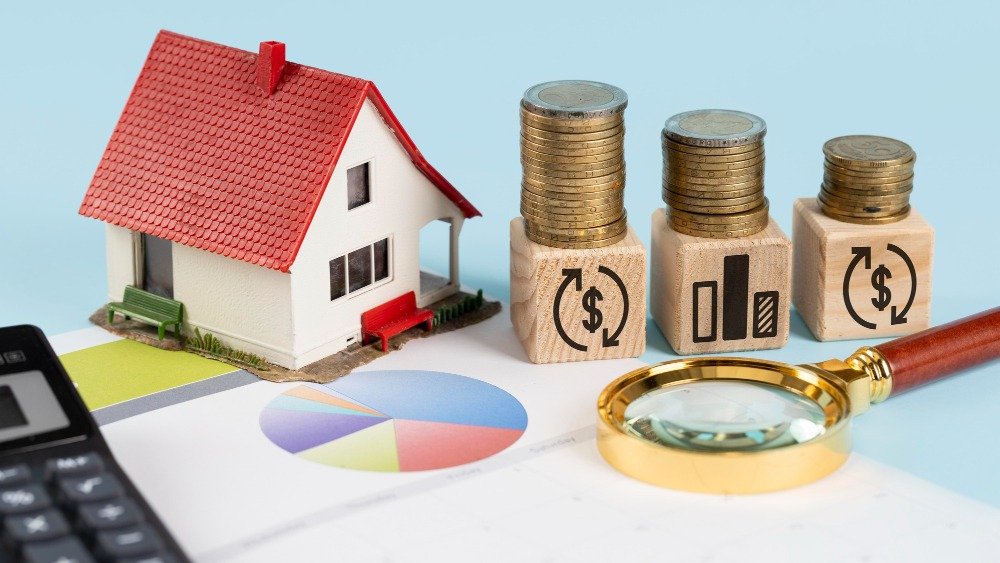Miniature house model, stacks of coins, and financial charts illustrate real estate investment concepts, highlighting potential returns and growth strategies.